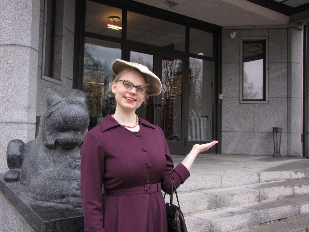 Nainen 1950-luvun vaatteissa Serlachius museo Gustafin edessä