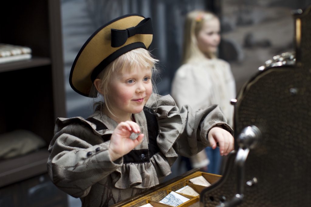 A girl at Museum Gustaf playing in the exhibition Apotheckary's Trade House.