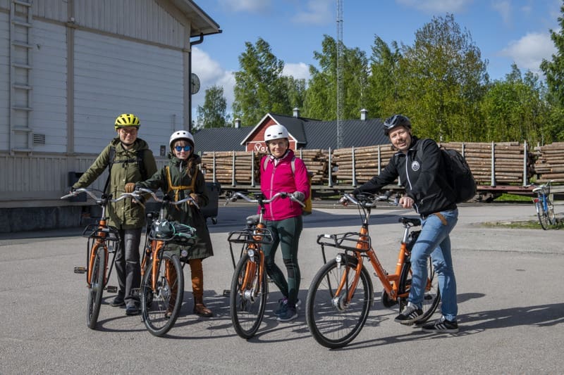 Neljä pyöräilijää poseeraa kameralle Vilppulan rautatieasemalla. 