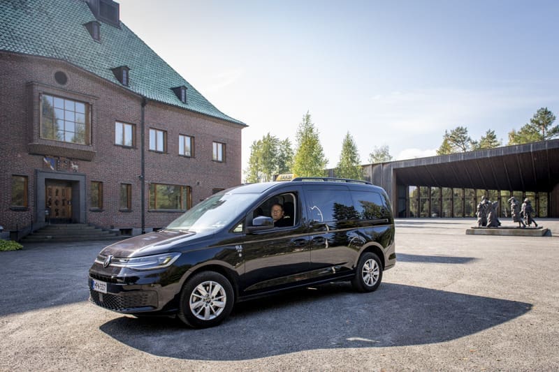 Musta taksiauto museon pääsisäänkäynnin edustalla