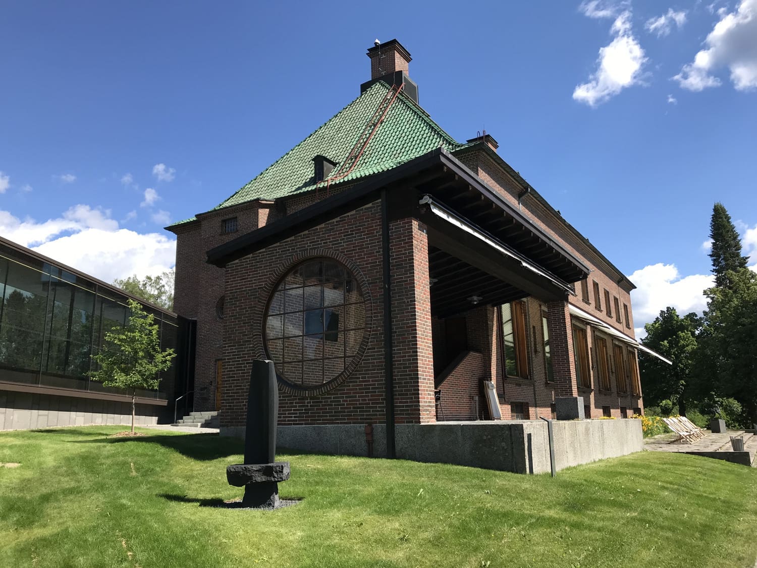 Ruskeatiilinen kartanorakennus viistosti kulmasta kuvattuna.