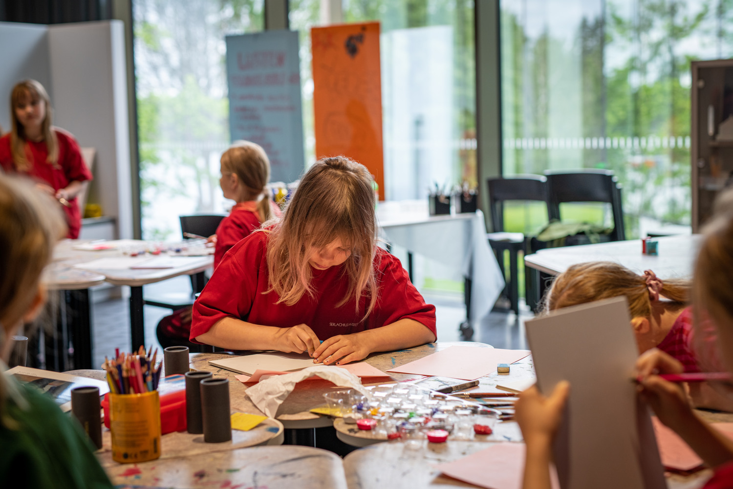 Lapset taiteilevat pölydän ääressä.