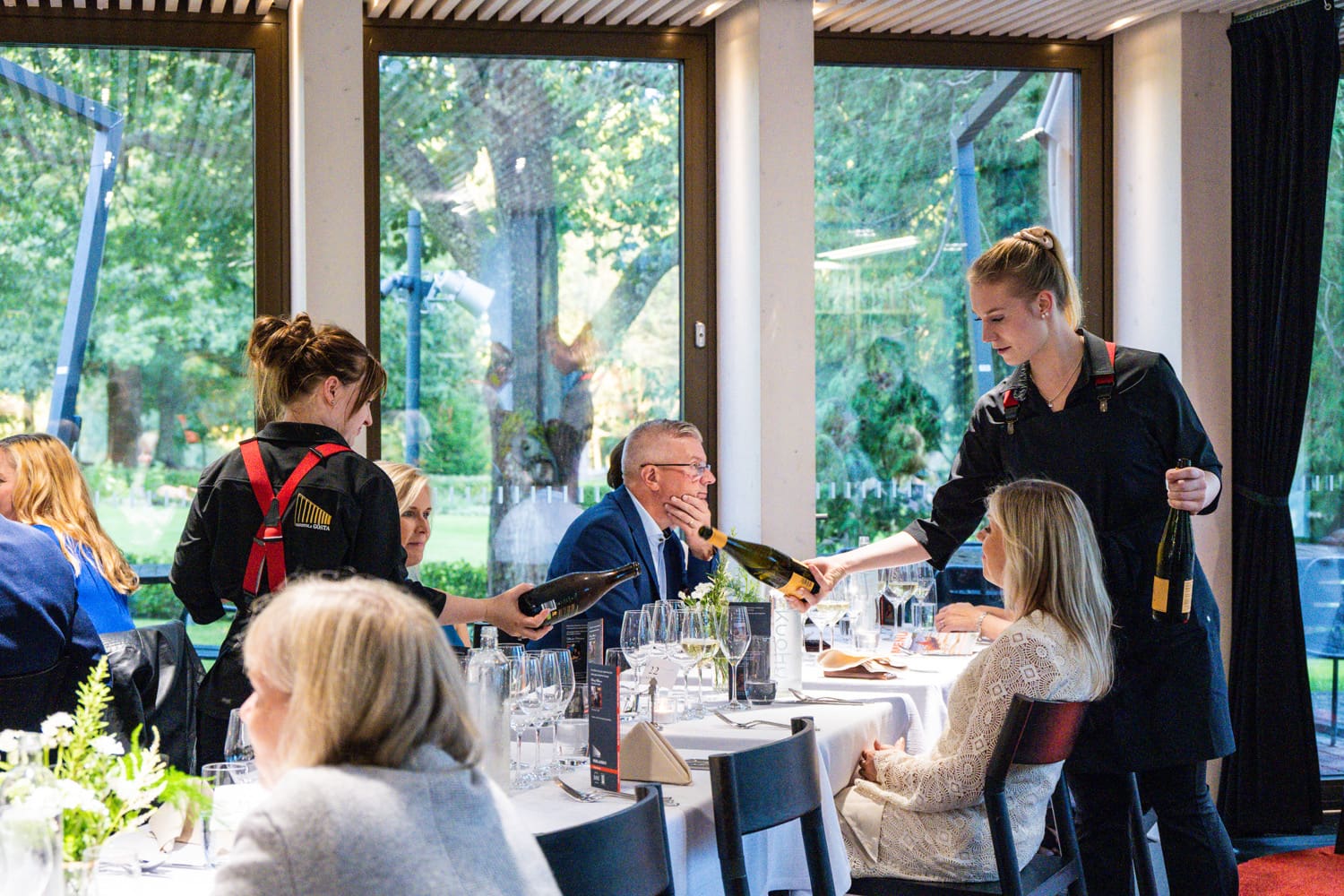 Tarjoilijat tarjoilevat pöytiin Mänttä Food Festivalin asiakkaille 2024.