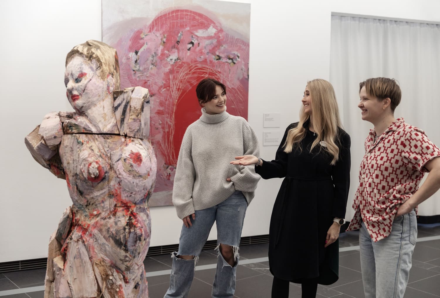 Nuoret ihmiset katsovat oppaan johdolla nykytaidetta.