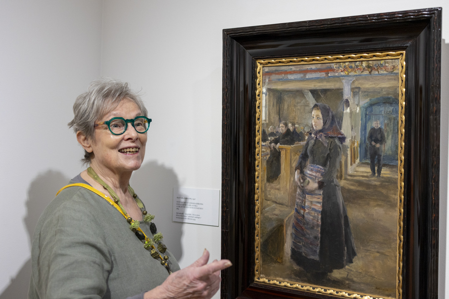 Harmaahiuksinen nainen katselee Akseli Gallen-Kallelan maalausta