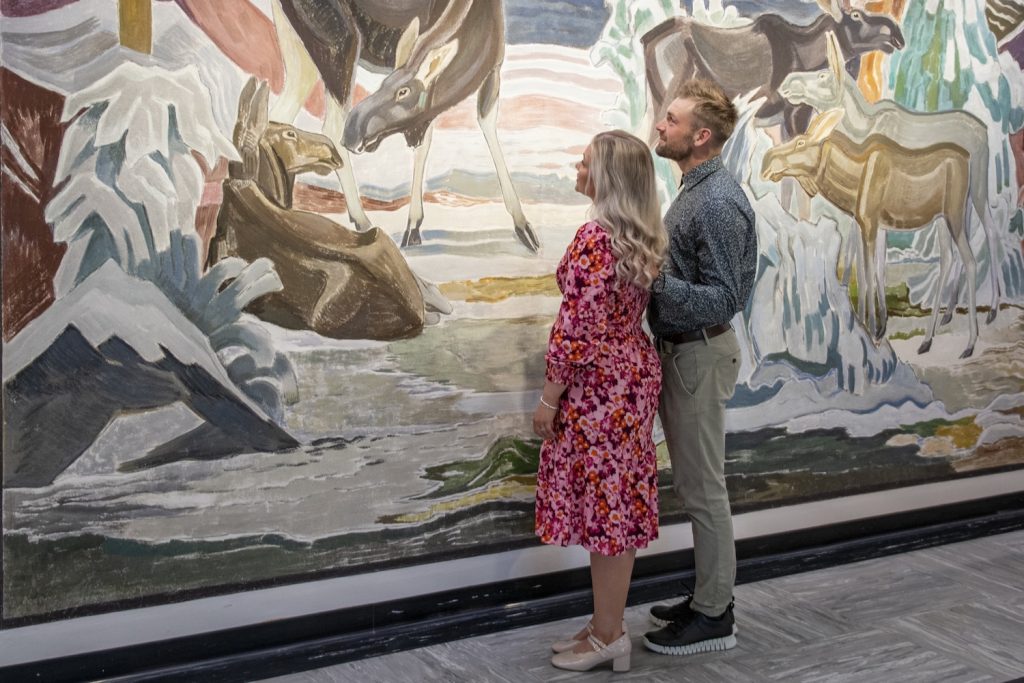 Mies ja nainen katsovat seinämaalausta.