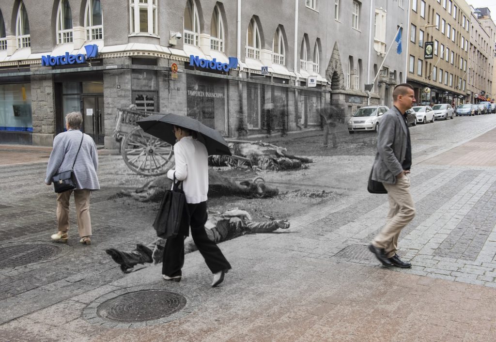 Vanhan ja uuden valokuvan yhdistävässä teoksessa sisällissodassa kuollut vainaja makaa kadulla, jossa nykyihmiset kulkevat.