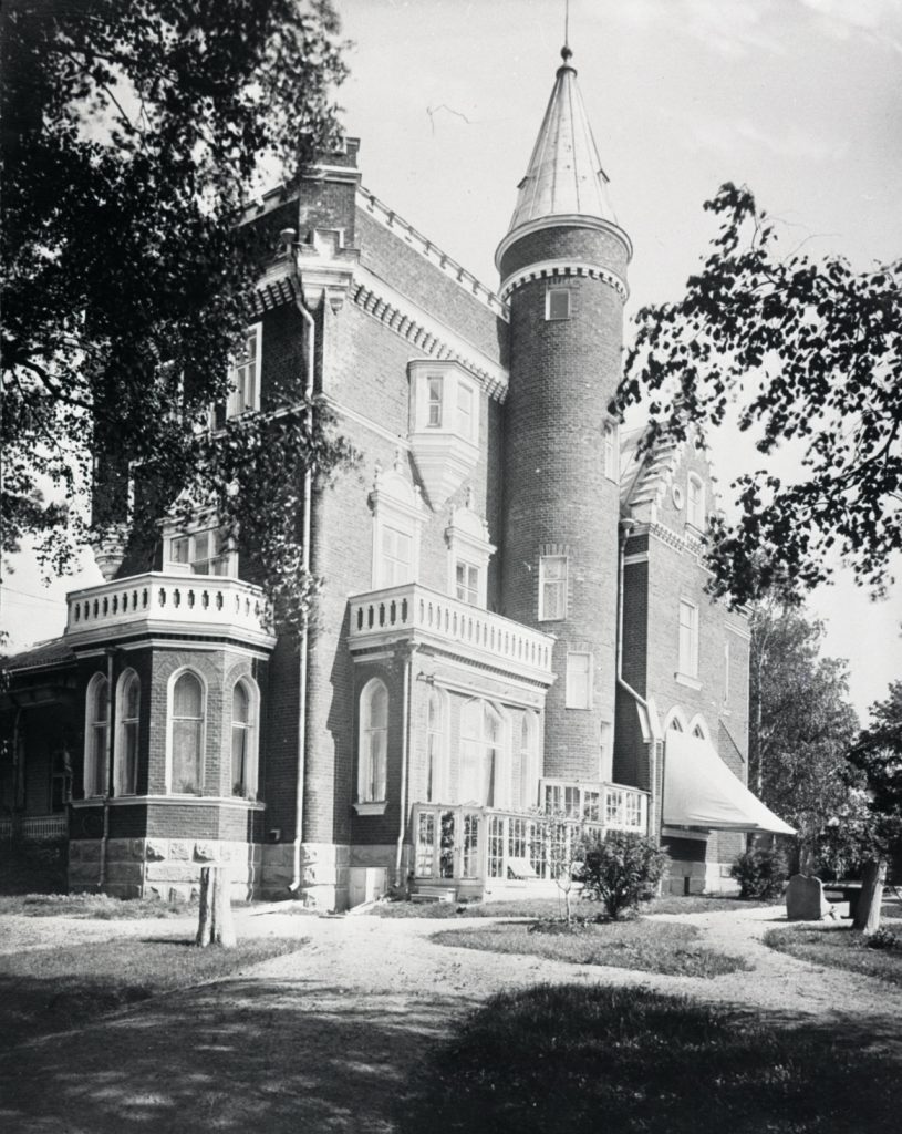 Vanhassa valokuvassa linnamainen rakennus torneineen.