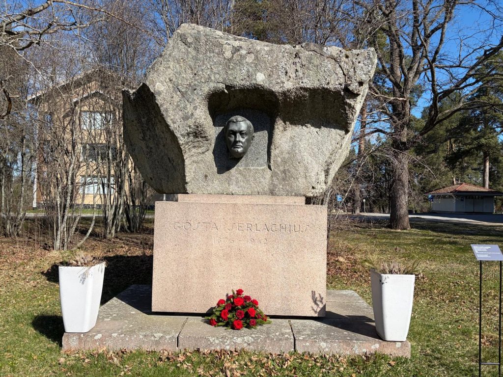 Gösta Serlachiuksen muistomerkki, johon on asetettu kukkalaite.