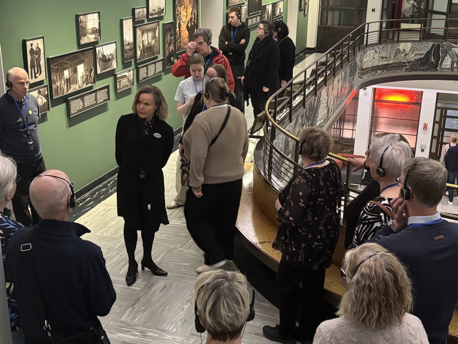 Opasta ympäröivät häntä kuuntelevat ihmiset.