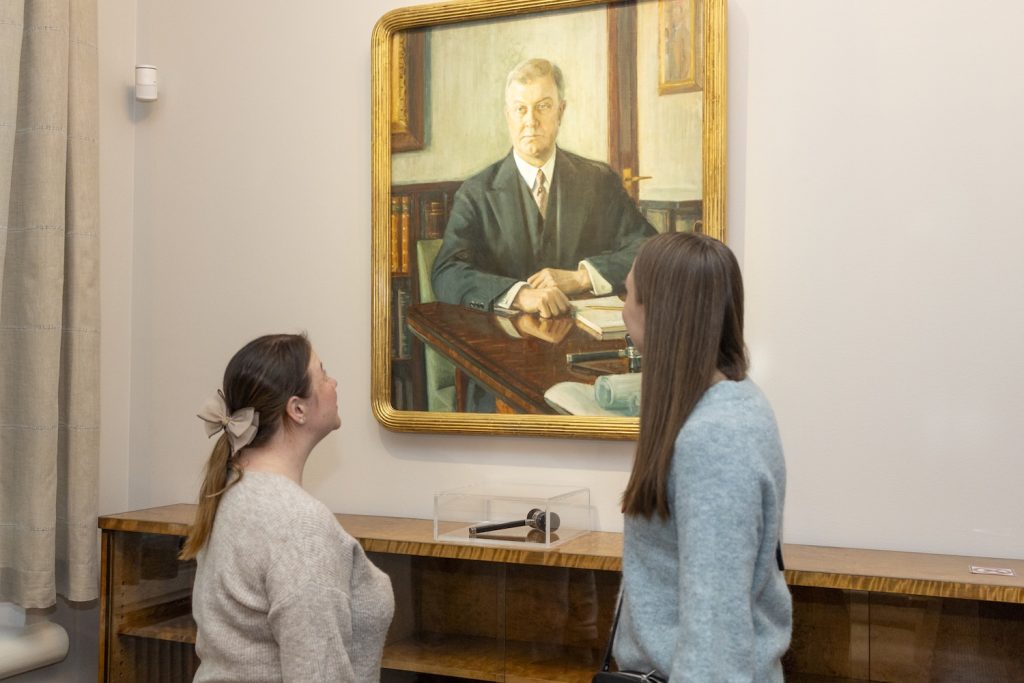 Kaksi naistya tutkii Gösta Serlachiuksen maalausta.