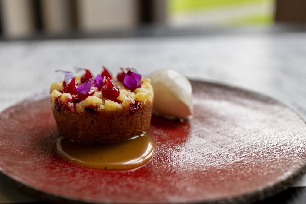 Leivos ja jäätelöjälkiruoka punaisella lautasella.