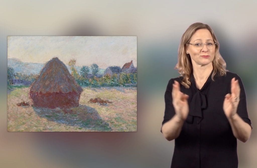 A woman gestures as she presents Claude Monet’s painting Haystack in the Evening Sun.